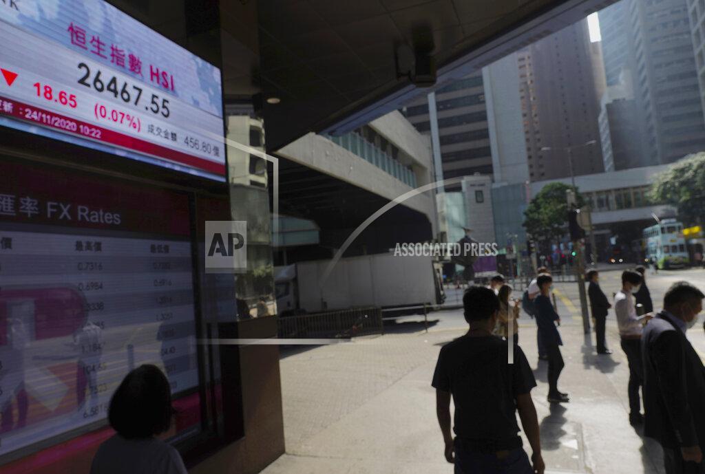 Vincent Yu People walk past a bank's electronic board showing the Hong Kong share index at Hong Kong Stock Exchange Tuesday, Nov. 24, 2020. Asian shares were mostly higher Tuesday, encouraged by news on the development of coronavirus vaccines and more assurance for a transition of power in the U.S. to President-elect Joe Biden. (AP Photo/Vincent Yu)