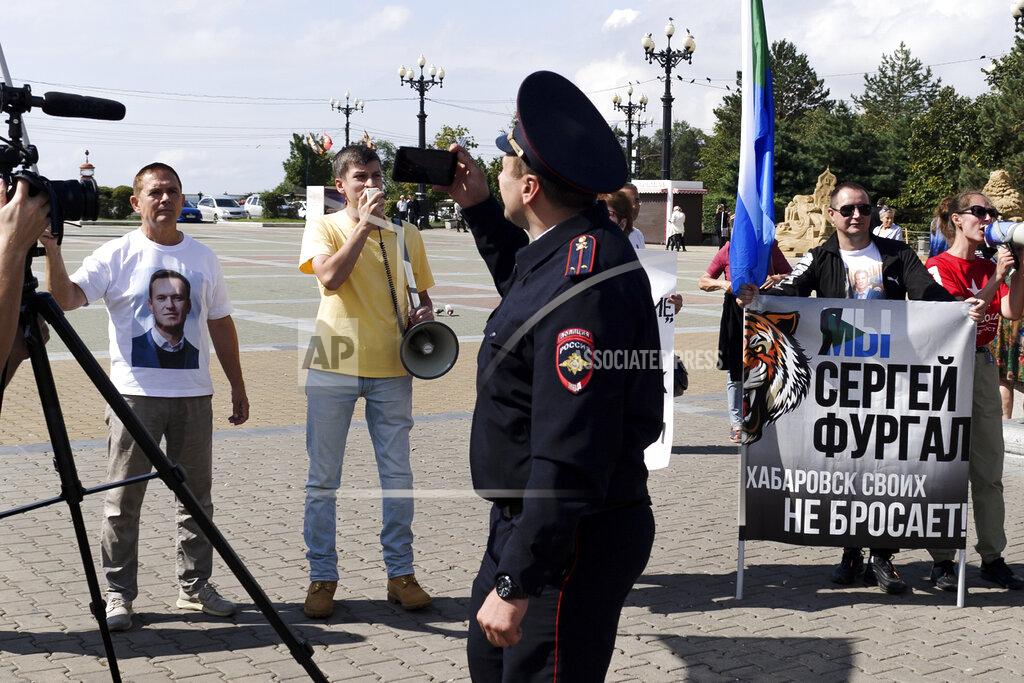 Sergei Demidov A police officer looks at a group of demonstrators in Khabarovsk, Russia, who had gathered in support of Sergei Furgal, the former governor of the region in the country's Far East, on Saturday, Sept. 11, 2021. A few demonstrators gather in a persistent reminder of the larger protests last year demanding the release of the region's former governor, Sergei Furgal. (AP Photo/Sergei Demidov)