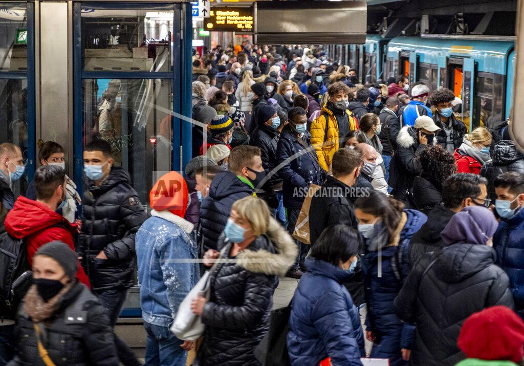 Michael Probst FILE - In this Dec. 2, 2020 file photo, people wear face masks but stand close together as they wait for a subway train in Frankfurt, Germany, Wednesday. More than 50,000 people have died after contracting COVID-19 in Germany, a number that has risen swiftly over recent weeks as the country has struggled to bring down infection figures. (AP Photo/Michael Probst, File)