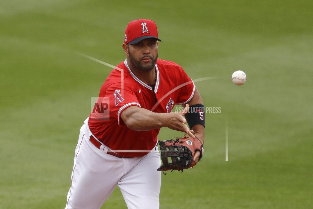 FILE - In this Feb. 28, 2020, file photo, Los Angeles Angels first baseman Albert Pujols throws the ball during the fourth inning of a spring training baseball game against the Texas Rangers in Tempe, Ariz. Pujols will pay the salaries of the Angels' furloughed employees in his native Dominican Republic for five months, a person with knowledge of the decision told The Associated Press. The person spoke on condition of anonymity Friday, June 19, 2020, because Pujols did not publicly announce his commitment to pay roughly $180,000 to cover the salaries. (AP Photo/Charlie Riedel, File)