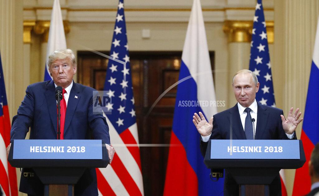 Alexander Zemlianichenko FILE - In this file photo taken on Monday, July 16, 2018, Russian President Vladimir Putin raises his hands as U.S. President Donald Trump, left, listens during a press conference after their meeting at the Presidential Palace in Helsinki, Finland. From Moscow, the U.S. election looks like a contest between "who dislikes Russia most," according to Kremlin spokesman Dmitry Peskov. Russian President Vladimir Putin is frustrated with President Donald Trump's failure to deliver on his promise to fix ties between the countries. But Democratic challenger Joe Biden does not offer the Kremlin much hope either. (AP Photo/Alexander Zemlianichenko, File)