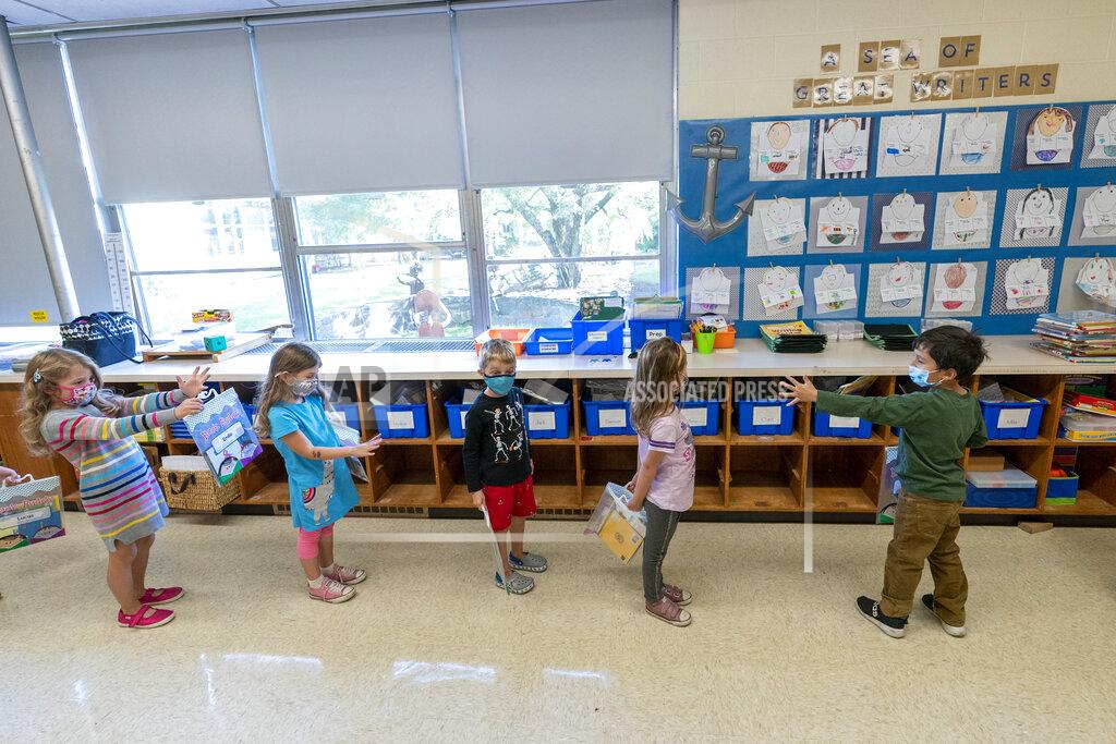 Mary Altaffer FILE - In this Oct. 6, 2020, file photo, kindergarten students check to make sure they are standing at the proper social distancing space as they line up to go outside during the coronavirus outbreak at the Osborn School, in Rye, N.Y. Schools and camps across the county are making plans to help kids catch up academically this summer after a year or more of remote learning for many of them. (AP Photo/Mary Altaffer, File)