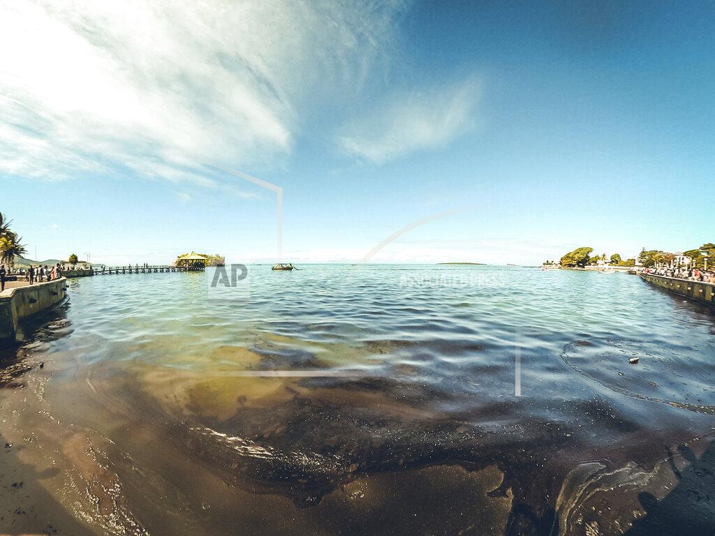 Uncredited In this photo provided by Grégoire Rouxel fuel is in the ocean leaking from a ship, rear right, that ran aground, Friday, Aug. 7, 2020, in Mauritius. The Indian Ocean island of Mauritius has declared a "state of environmental emergency" after a Japanese-owned ship that ran aground offshore days ago began spilling tons of fuel. Prime Minister Pravind Jugnauth announced the development late Friday, Aug. 7, 2020, as satellite images showed a dark slick spreading near environmental areas the government called "very sensitive." (@gregrouxel via AP)