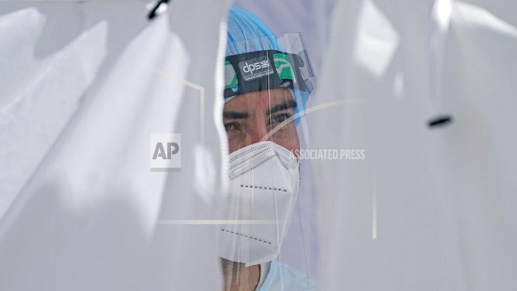 A National Guardsman looks on at the Utah National Guard's mobile testing site for COVID-19 Thursday, Nov. 12, 2020, in Salt Lake City. The state recorded 3,919 new confirmed cases of the coronavirus, which brought the seven-day average of new daily cases to 2,738. In the past week, Utah's positivity average has increased from 19.5% to 23.2%, according to state data. (AP Photo/Rick Bowmer)