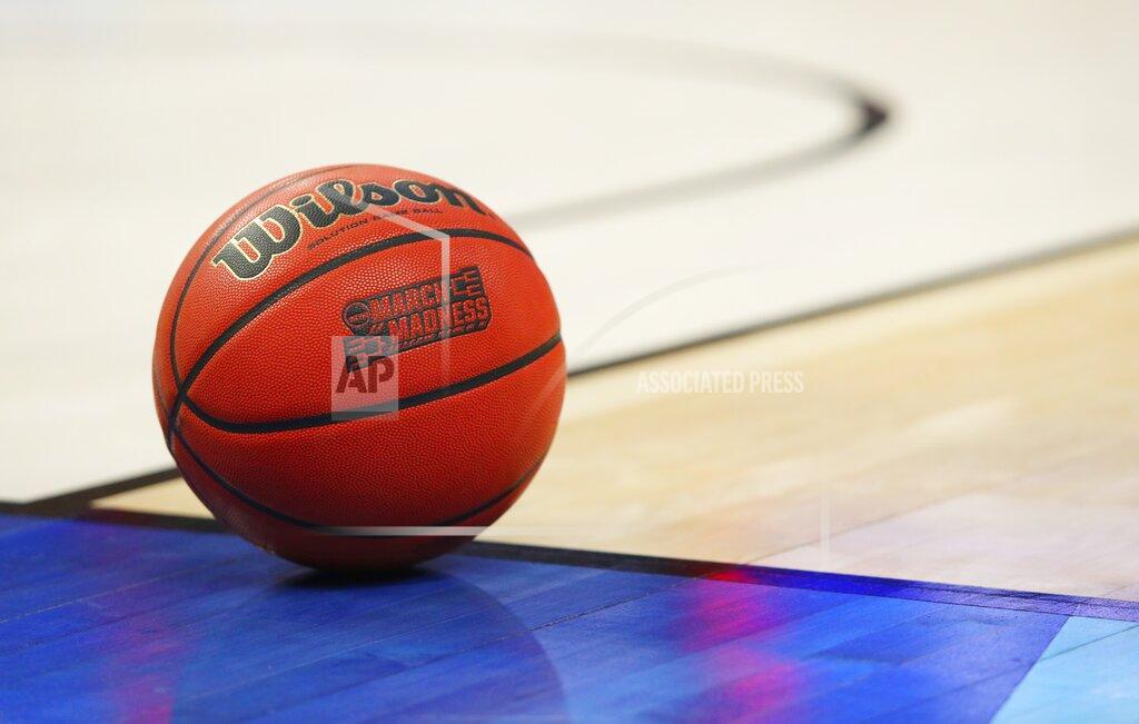 Bill Wippert FILE -- In this March 18, 2017, file photo, an official game ball with the March Madness logo sits in the court during a second-round men's college basketball game between Villanova and Wisconsin in the NCAA Tournament in Buffalo, N.Y. Coaches did the best they could to prepare for the big moment, yet still find themselves in a scramble once it actually happened. The NCAA announced last month that the season would begin on Nov. 25 and teams are still trying to fill all the holes in their schedules. (AP Photo/Bill Wippert, File)