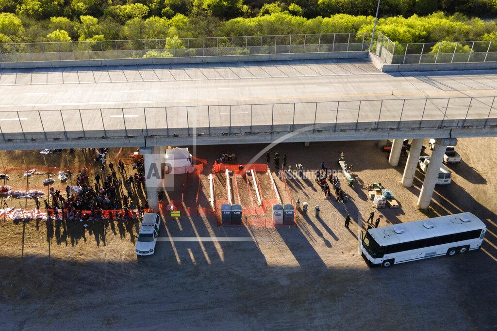 Julio Cortez In this photo taken by a drone, migrants are seen in custody at a U.S. Customs and Border Protection processing area under the Anzalduas International Bridge, Thursday, March 18, 2021, in Mission, Texas. A surge of migrants on the Southwest border has the Biden administration on the defensive. The head of Homeland Security acknowledged the severity of the problem Tuesday but insisted it's under control and said he won't revive a Trump-era practice of immediately expelling teens and children. (AP Photo/Julio Cortez)