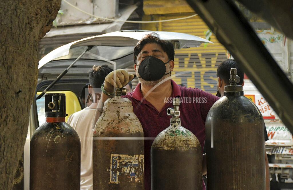 Ishant Chauhan Family member of a COVID-19 patient reacts as he waits to refill an oxygen cylinder at a gas supplier facility in New Delhi, India, Saturday, May 8, 2021. Infections have swelled in India since February in a disastrous turn blamed on more contagious variants as well as government decisions to allow massive crowds to gather for religious festivals and political rallies. (AP Photo/Ishant Chauhan)