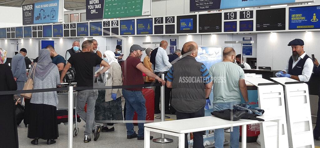 Nick Ansell Passengers in a queue at Stansted Airport, north of London, to check-in for a flight bound for Adana, Turkey, Wednesday June 3, 2020, as new quarantine rules for travellers arriving in the UK are to be set out by Home Secretary Priti Patel. The plans, due to come into force on June 8, will see people arriving in the UK told to isolate for 14-days to prevent coronavirus cases being introduced from overseas. (Nick Ansell/PA via AP)