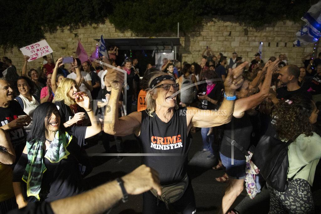 Ariel Schalit Israeli protesters dance and cheer during a demonstration against Israeli Prime Minister Benjamin Netanyahu outside his official residence in Jerusalem, Saturday, June 12, 2021. If all goes according to plan, Israel will swear in a new government on Sunday, ending Prime Minister Benjamin Netanyahu's record 12-year rule and a political crisis that inflicted four elections on the country in less than two years. (AP Photo/Ariel Schalit)