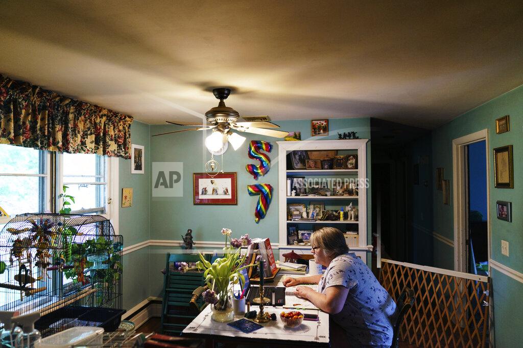 David Goldman Ellen Booth, 57, studies at her kitchen table to become a certified medical coder, in Coventry, R.I., Monday, May 17, 2021. When the restaurant she worked for closed last year, Booth said it gave her "the kick I needed." She started a year-long class to learn to be a medical coder. When her unemployment benefits ran out two months ago, she started drawing on her retirement funds. Booth hopes to pass her upcoming exam and soon hit the job market. (AP Photo/David Goldman)