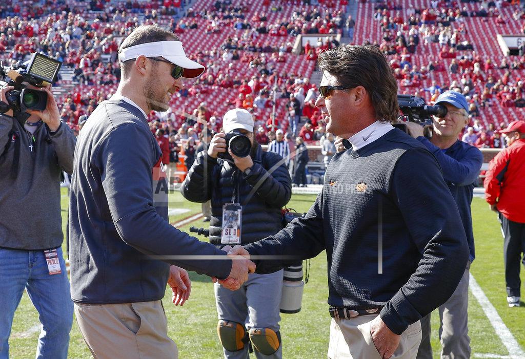 Alonzo Adams Oklahoma head coach Lincoln Riley, left, and Oklahoma State head coach Mike Gundy, right, meet mid field before the start of an NCAA college football game in Norman, Okla., Saturday, Nov. 10, 2018. (AP Photo/Alonzo Adams)
