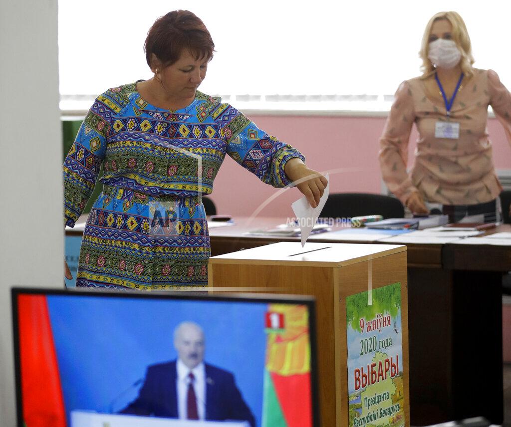 Sergei Grits A woman votes at a polling station during a early voting ahead of Sunday's election while live broadcast of Belarus President Alexander Lukashenko's speech in Minsk, Belarus, Tuesday, Aug. 4, 2020. Belarus's authoritarian leader is vowing to maintain a close alliance with Russia despite the latest tensions as he seeks a sixth term in office amid a surge of opposition protests. President Alexander Lukashenko's comments in a state-of-the-nation address ahead of Sunday's election contrast with his diatribes against Russia last week. (AP Photo/Sergei Grits)
