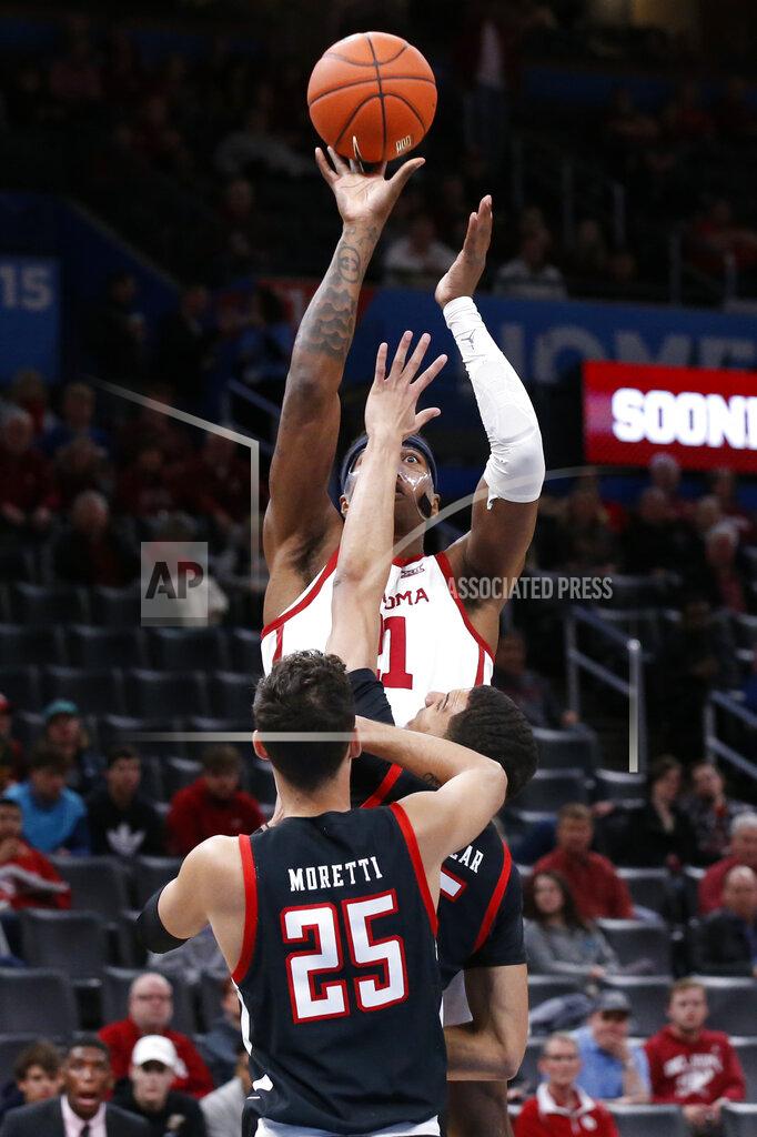 Sue Ogrocki Oklahoma forward Kristian Doolittle, rear, shoots over Texas Tech guard Davide Moretti (25) and guard Kevin McCullar, center, in the first half of an NCAA college basketball game Tuesday, Feb. 25, 2020, in Oklahoma City. (AP Photo/Sue Ogrocki)