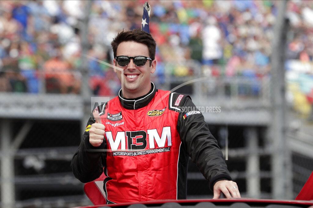 John Raoux FILE - In this Sunday, Feb. 16, 2020, file photo, Timmy Hill takes a parade lap in front of fans before the NASCAR Daytona 500 auto race at Daytona International Speedway in Daytona Beach, Fla. Virtual racing has been the small saving grace for motorsports since the coronavirus global pandemic brought nearly everything to a halt. For journeyman driver Timmy Hill, his iRacing victory on national television gave Hill and his sponsors exposure they'd never receive during a normal NASCAR weekend. (AP Photo/John Raoux, File)