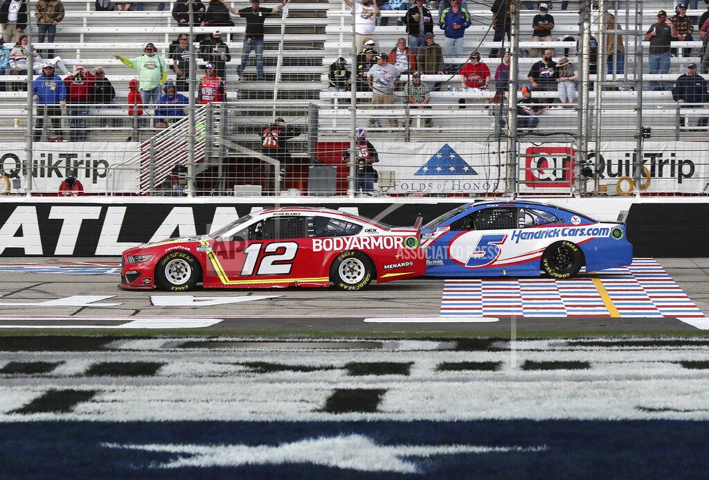 Curtis Compton Ryan Blaney (12) passes Kyle Larson with eight laps remaining on his way to winning a NASCAR Cup Series auto race at Atlanta Motor Speedway on Sunday, March 21, 2021, in Hampton, Ga. (Curtis.Compton/Atlanta Journal-Constitution via AP)