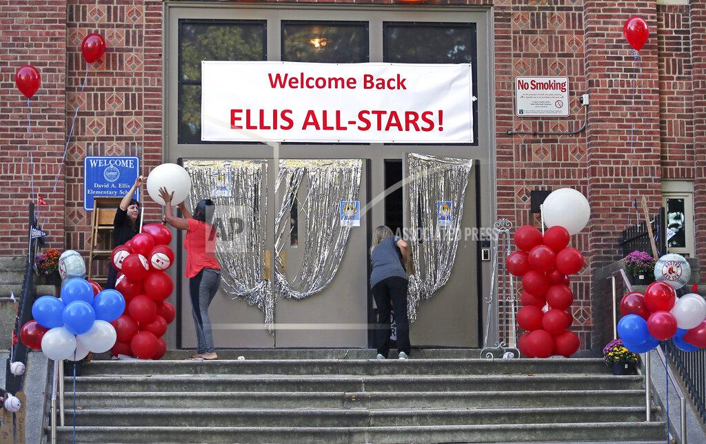 David L. Ryan/Globe Staff School staff help to decorate the front entrance of the Ellis Elementary School in Boston's Roxbury neighborhood before opening for the first day back of in person learning during the COVID-19 coronavirus pandemic, Thursday, Oct. 1, 2020. Boston is delaying plans to reopen the city's schools after the city's coronavirus positivity rate climbed higher than 4%, Mayor Marty Walsh announced Wednesday, Oct. 7. Some students, including those with special needs, those dealing with homelessness, and those who are in state care have already been allowed to return to in-person classes. They will continue to be taught in person, the mayor said. (David L Ryan/The Boston Globe via AP)