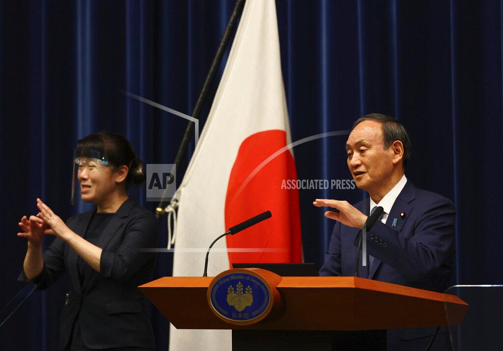 Issei Kato Japan's Prime Minister Yoshihide Suga (R) attends a news conference on Japan's response to the coronavirus pandemic during the Tokyo 2020 Olympic Games in Tokyo, Japan, Friday, July 30, 2021. Suga expanded a coronavirus state of emergency to four more areas in addition to Tokyo on Friday following record spikes in infections as the capital hosts the Olympics. (Issei Kato/Pool Photo via AP)