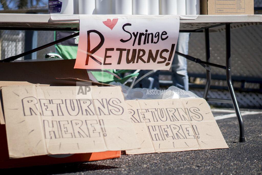 Chad Cordell In this photo provided by Chad Cordell, signs for syringe returns are shown Saturday, March 6, 2021, at a nonprofit group's health fair in Charleston, W.Va. For years, West Virginia has had the nation's highest rate of drug overdose deaths. Now the state is wrestling with another, not entirely unrelated health emergency: a spike in HIV cases related to intravenous drug use. (Chad Cordell via AP)