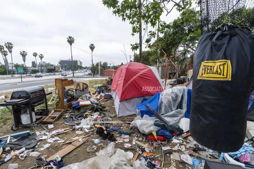 Damian Dovarganes A trashed punching bag is left at a homeless encampment is seen on the side of the CA-101 highway in Echo Park neighborhood in Los Angeles Tuesday, May 11, 2021. California Gov. Gavin Newsom on Tuesday proposed $12 billion in new funding to get more people experiencing homelessness in the state into housing and to “functionally end family homelessness” within five years. (AP Photo/Damian Dovarganes)