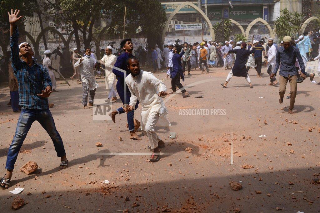 Mahmud Hossain Opu Two factions of protestors clash after Friday prayers at Baitul Mokarram mosque in Dhaka, Bangladesh, Friday, March 26, 2021. Witnesses said violent clashes broke out after one faction of protesters began waving their shoes as a sign of disrespect to Indian Prime Minister Narendra Modi, and another group tried to stop them. Local media said the protesters who tried to stop the shoe-waving are aligned with the ruling Awami League party. The party criticized the other protest faction for attempting to create chaos in the country during Modi’s visit. (AP Photo/Mahmud Hossain Opu)