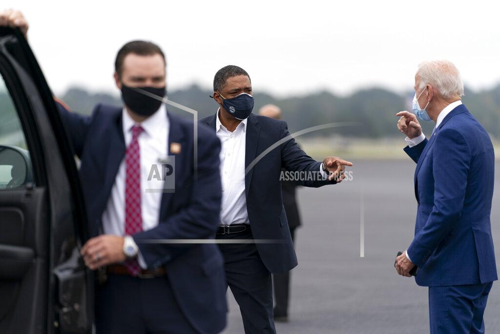 Andrew Harnik Democratic presidential candidate former Vice President Joe Biden speaks with Rep. Cedric Richmond, D-La., center, as he arrives at Columbus Airport in Columbus, Ga., Tuesday, Oct. 27, 2020, to travel to Warm Springs, Ga. for a rally. (AP Photo/Andrew Harnik)