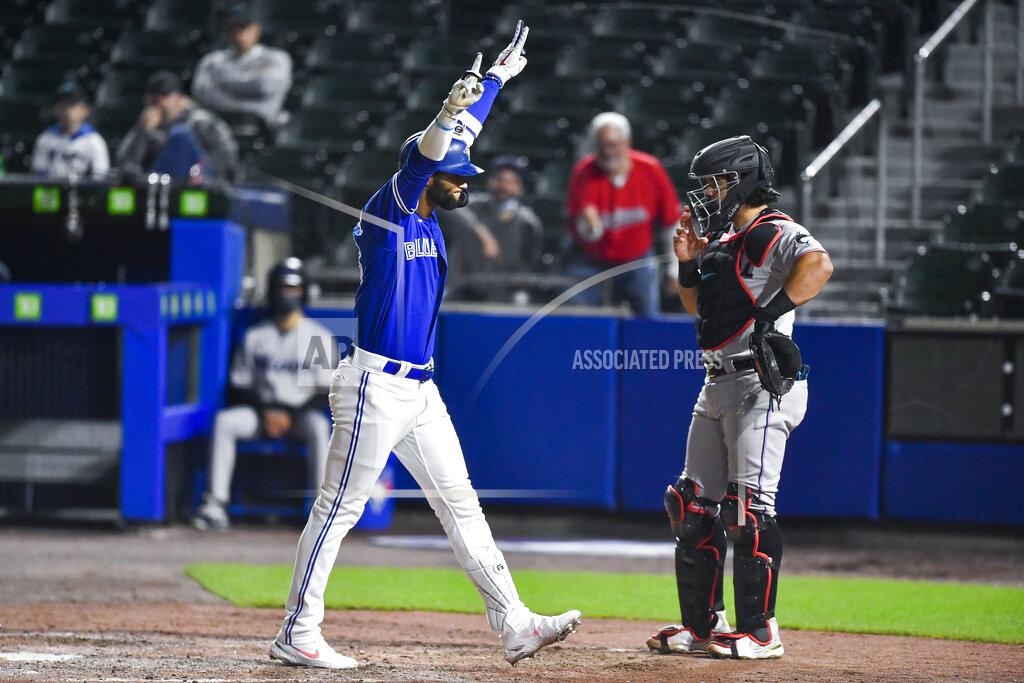 Adrian Kraus Toronto Blue Jays' Lourdes Gurriel Jr., left, celebrates in front of Miami Marlins catcher Jorge Alfaro, right, after hitting a solo home run during the eighth inning of a baseball game in Buffalo, N.Y., Tuesday, June 1, 2021. (AP Photo/Adrian Kraus)