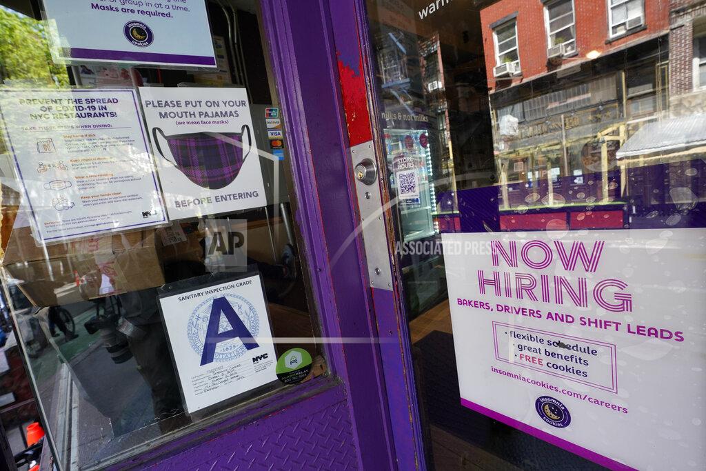 FILE - In this May 4, 2021 file photo, a signs announcing they are hiring hangs in the window of a restaurant in the Greenwich Village neighborhood of Manhattan in New York. The economic recovery’s seemingly open road ahead could get a little bumpy from here. The employment market, a key factor in a full recovery from the pandemic, has been stubbornly lagging behind. (AP Photo/Mary Altaffer, File)