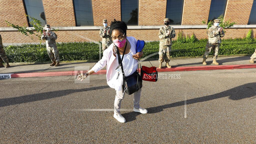 A G.V. (Sonny) Montgomery VA Medical Center employee takes a bow to the applause from members of the Mississippi Air and Army National Guard as he walks towards the entrance, in Jackson, Miss., Tuesday, May 12, 2020. The guardsmen and women honored medical personnel for their efforts in working with the coronavirus on the final day of National Nurses Week. May 12, is the birthday of Florence Nightingale, who is credited as the founder of modern nursing. (AP Photo/Rogelio V. Solis)