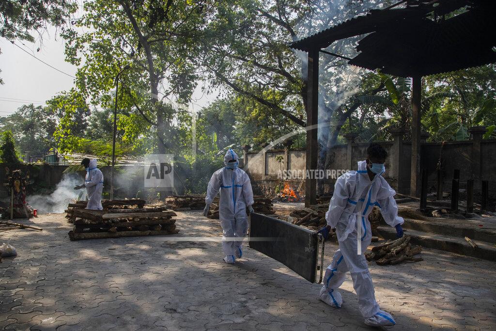Anupam Nath Indian health workers in protective suit return after bringing the body of a person who died of COVID-19 for cremation in Gauhati, India, Tuesday, April 27, 2021. The COVID-19 death toll in India has topped 200,000 as the country endures its darkest chapter of the pandemic yet. (AP Photo/Anupam Nath)