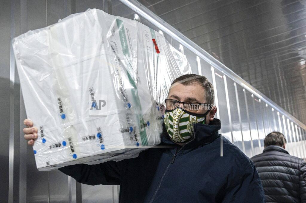 Zsolt Szigetvary Employees unload the newly arrived coronavirus vaccines from Chinese pharmaceutical company Sinopharm at the logistics base set up to in the parking lot of the government office in the 13th district of Budapest, Hungary, March 3, 2021. (Zsolt Szigetvary/MTI via AP)