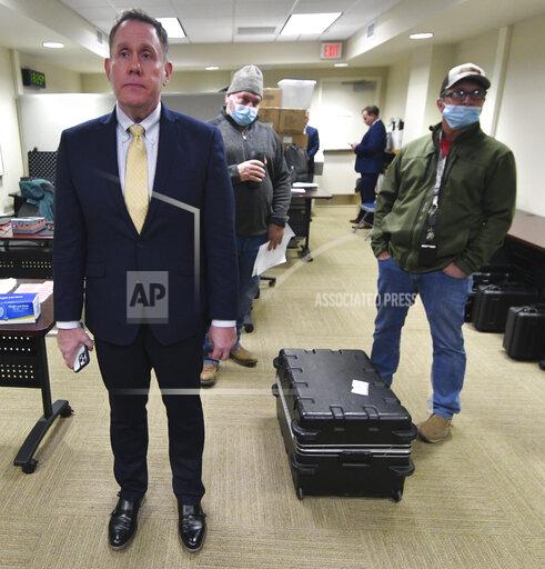 Thomas Breth, left, a lawyer for Fulton County, Pa., stands with other county officials and explains that the state Supreme Court had just put their voting machine inspection on hold before it started in McConnellsburg, Pa., Friday, Jan. 14, 2022. (AP Photo/Marc Levy)
