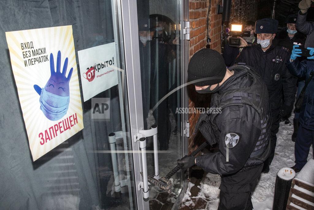 Pavel Golovkin FILE - In this Dec. 26, 2020, file photo, Russian police break the door of a bar for violating a mayoral decree that said businesses must close at 11 p.m. in Moscow, Russia, due to the coronavirus. Some owners of businesses disobeyed the virus restrictions in Moscow and St. Petersburg. (AP Photo/Pavel Golovkin, File)