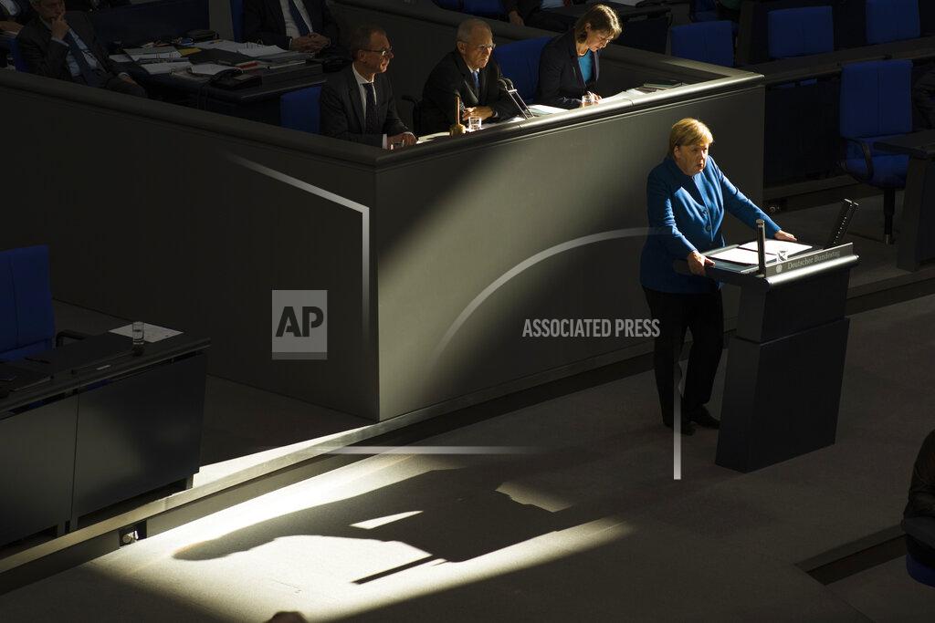 Markus Schreiber FILE - In this Wednesday, Oct. 17, 2018 file photo, German Chancellor Angela Merkel casts a shadow as she delivers a speech on the Europe-Britain 'Brexit' negotiations and the upcoming meeting of European leaders in Brussels during a meeting of the German federal parliament, Bundestag, at the Reichstag building in Berlin, Germany. German voters elect a new parliament on Sunday, Sept. 26, 2021, a vote that will determine who succeeds Chancellor Angela Merkel after her 16 years in power. (AP Photo/Markus Schreiber, File)