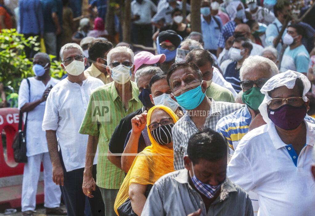 Rafiq Maqbool FILE - In this April 26, 2021, file photo, people queue up for coronavirus vaccine in Mumbai, India. The disparities of the coronavirus pandemic were already stark in India, where access to health care is as stratified and unequal as other parts of its society. Now, the divide along the lines of wealth and technology are further widening that chasm, and many people are falling through the gaps as vaccines remain inaccessible to millions. (AP Photo/Rafiq Maqbool, File)
