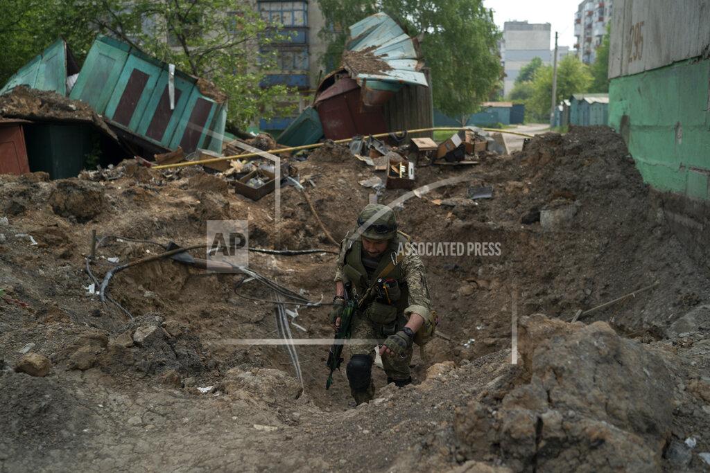 Leo Correa A special task force policeman inspects a site after an airstrike by Russian forces in Lysychansk, Luhansk region, Ukraine, Friday, May 13, 2022. (AP Photo/Leo Correa)