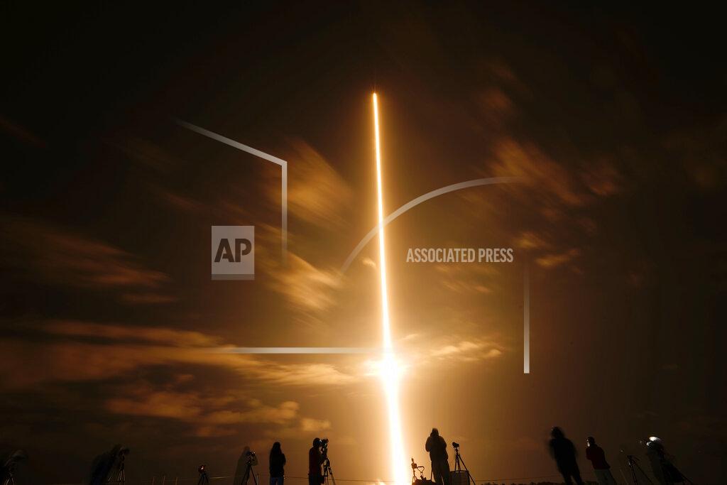 Brynn Anderson In this long exposure photo, photographers watch a SpaceX Falcon 9 rocket with the Crew Dragon space capsule lifts off from pad 39A at the Kennedy Space Center in Cape Canaveral, Fla., Friday, April 23, 2021. (AP Photo/Brynn Anderson)