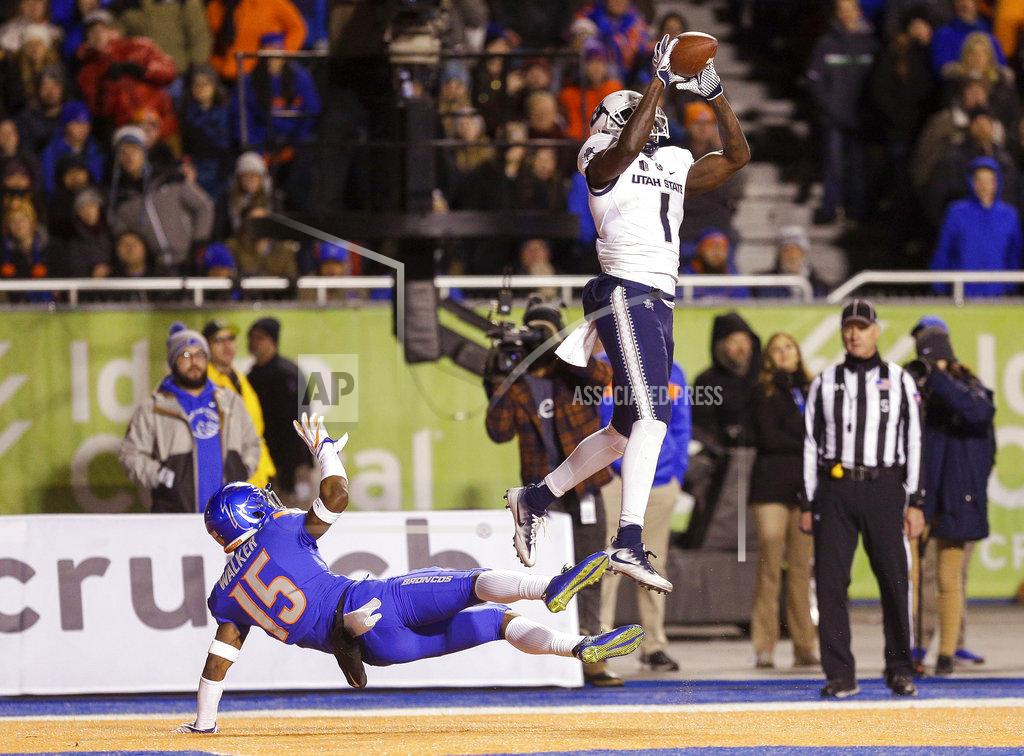 Steve Conner Utah State wide receiver Ron'quavion Tarver (1) catches a touchdown pass over Boise State cornerback Jalen Walker (15) during the first half of an NCAA college football game Saturday, Nov. 24, 2018, in Boise, Idaho. (AP Photo/Steve Conner)