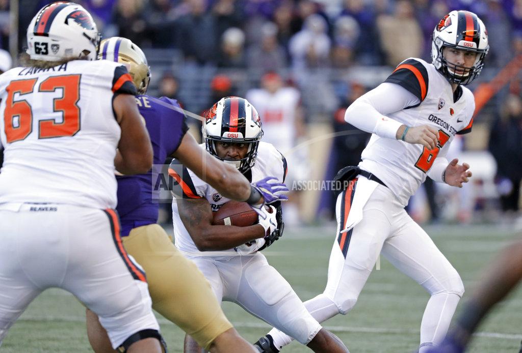 Elaine Thompson Oregon State quarterback Jake Luton, right, watches after handing off the ball to Artavis Pierce in the first half of an NCAA college football game against Washington, Saturday, Nov. 17, 2018, in Seattle. (AP Photo/Elaine Thompson)