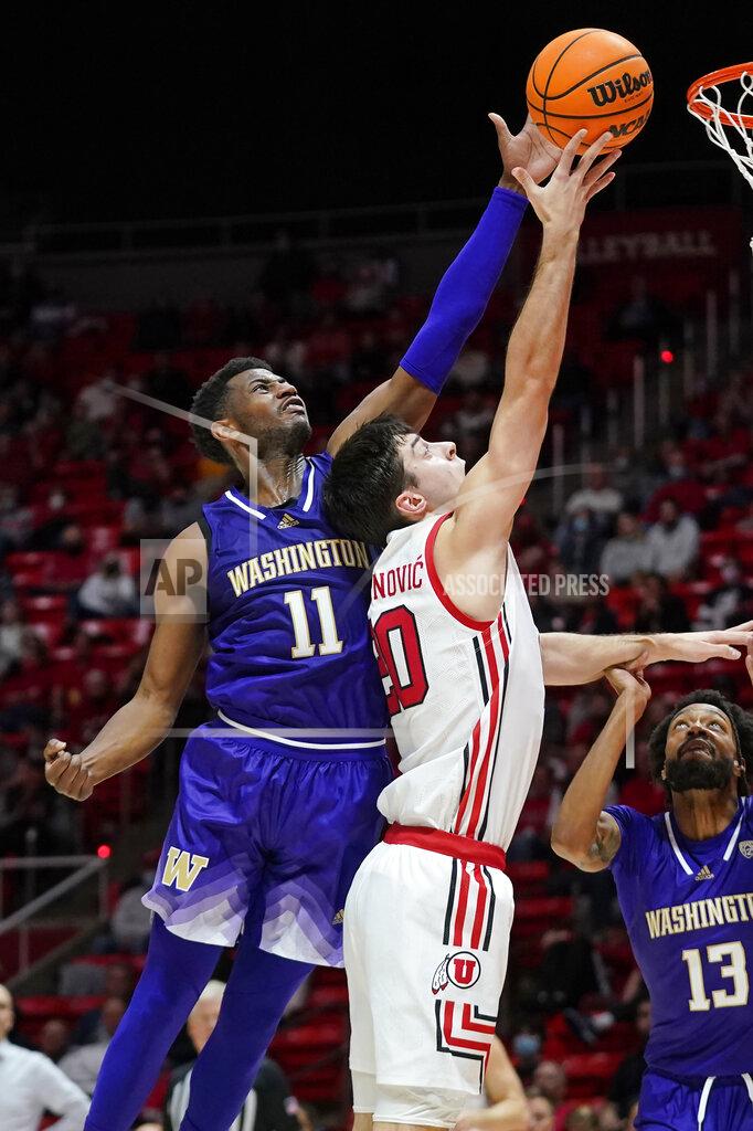 Rick Bowmer Washington guard Daejon Davis (11) blocks the shot of Utah guard Lazar Stefanovic (20) during the second half of an NCAA college basketball game Thursday, Jan. 6, 2022, in Salt Lake City. (AP Photo/Rick Bowmer)