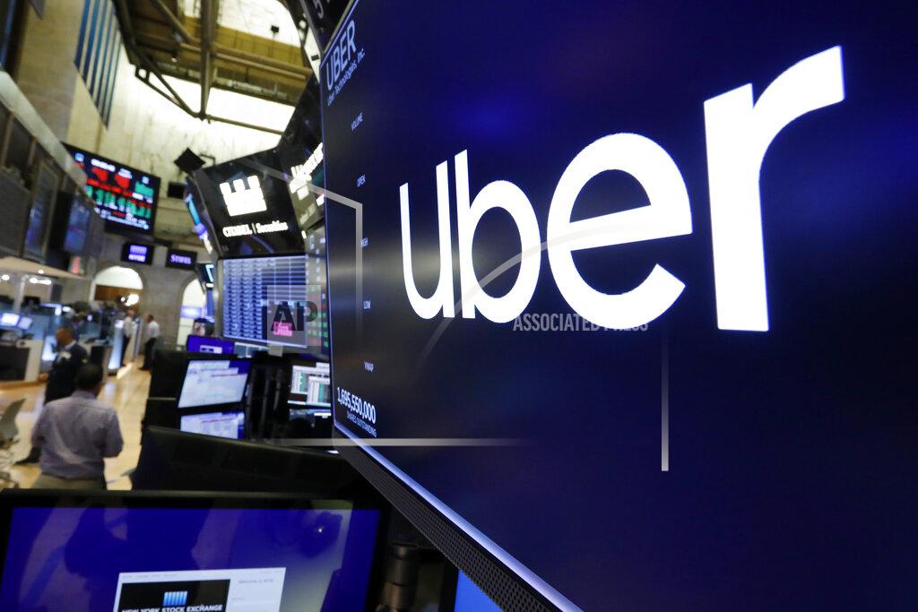 FILE - This Aug. 9, 2019 file photo, the logo for Uber appears above a trading post on the floor of the New York Stock Exchange. Uber lost $1.78 billion in the second quarter of 2020 as the pandemic carved a gaping hole in its ride-hailing business, with millions of people staying home to reduce the spread of the coronavirus. Its food delivery business grew as more people ordered in, but that growing part of its business didn’t turn a profit. (AP Photo/Richard Drew, File)