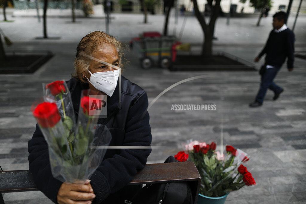 Rebecca Blackwell Wearing a mask to curb the spread of the new coronavirus, Martha Gonzalez Reyes, 76, sells roses outside Metro Hidalgo in central Mexico City, Monday, Aug. 10, 2020. After four months at home, Gonzalez returned to selling on August 1, but said business hasn't fully rebounded. "People have less money to spend, and they don't want to go out and get infected," said Gonzalez. (AP Photo/Rebecca Blackwell)