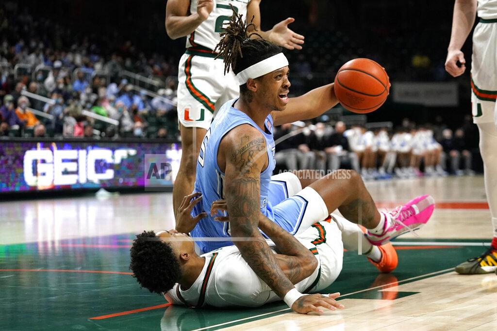 Lynne Sladky North Carolina forward Armando Bacot (5) commits a foul as Miami guard Jordan Miller falls to the court during the first half of an NCAA college basketball game, Tuesday, Jan. 18, 2022, in Coral Gables, Fla. (AP Photo/Lynne Sladky)