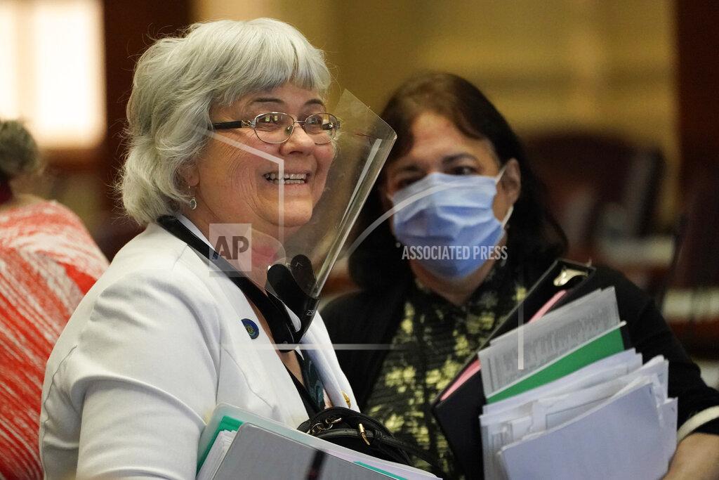 Robert F. Bukaty Rep. Abigail Griffin, R-Levant, left, wears a face shield uring the first legislative session in the State House since the proceedings were moved to the more spacious Augusta Civic Center, Wednesday, June 2, 2021, in Augusta, Maine. (AP Photo/Robert F. Bukaty)