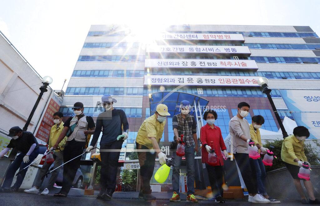 Park Chul-Hong Health officials disinfect an area around a hospital after one of the hospital's patients tested positive for the new coronavirus in Gwangju, South Korea, Wednesday, July 1, 2020. South Korea is considering including religious facilities on the same list with nightclubs, hostess bars and karaoke rooms as "high risk" venues for the spread of COVID-19 following a slew of transmissions tied to church gatherings. (Park Chul-hong/Yonhap via AP)