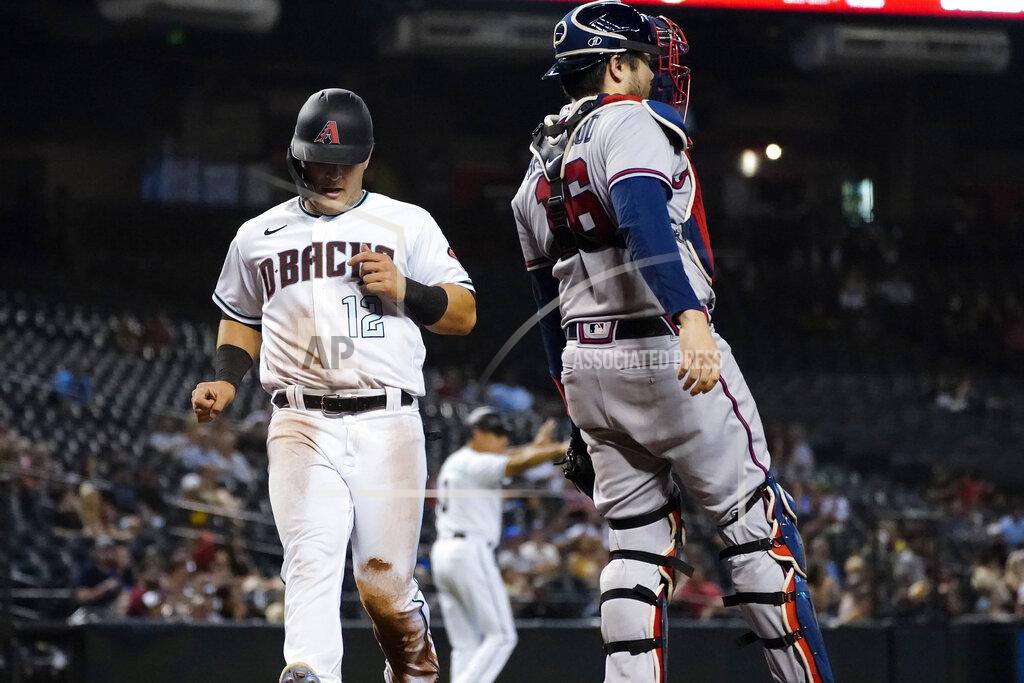 Matt York Arizona Diamondbacks' Daulton Varsho (12) scores on a ground out hit by Pavin Smith during the third inning of a baseball game as catcher Travis d'Arnaud looks on, Tuesday, Sept. 21, 2021, in Phoenix. (AP Photo/Matt York)