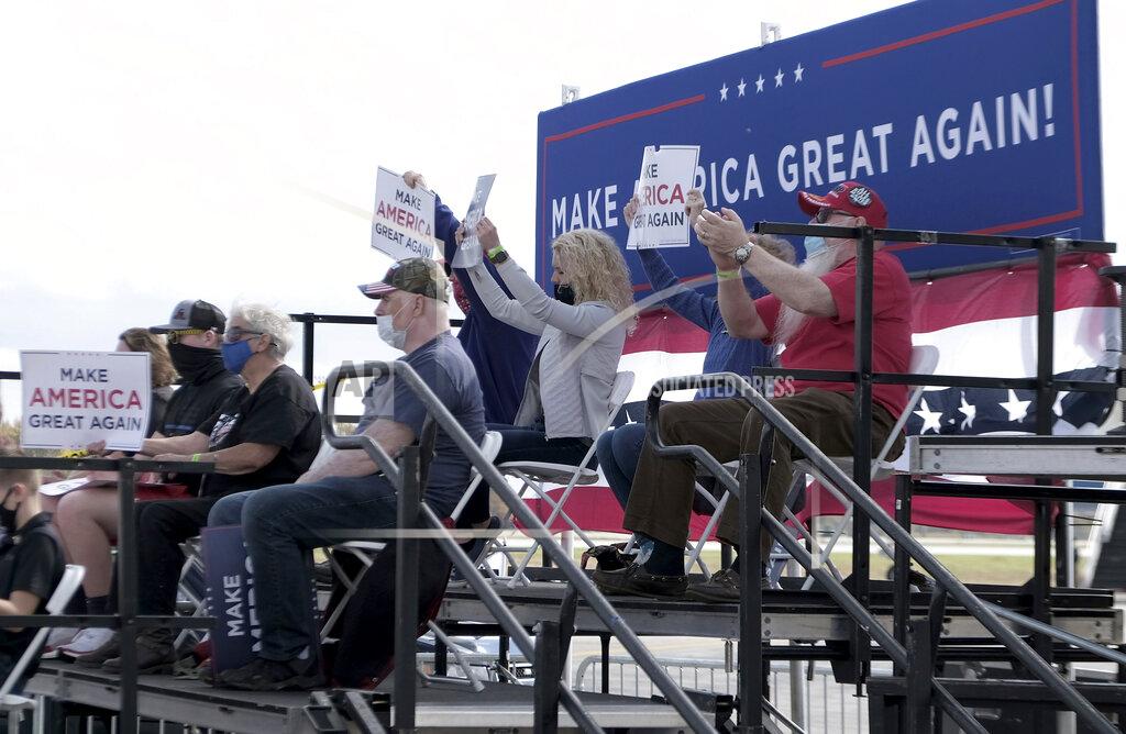 Lori King Supporters of Vice President Mike Pence hold up signs during his rally at the Grand Aire hanger of the Eugene F. Kranz Toledo Express Airport in Swanton, Ohio on Friday, Oct. 23, 2020. (Lori King/The Blade via AP)