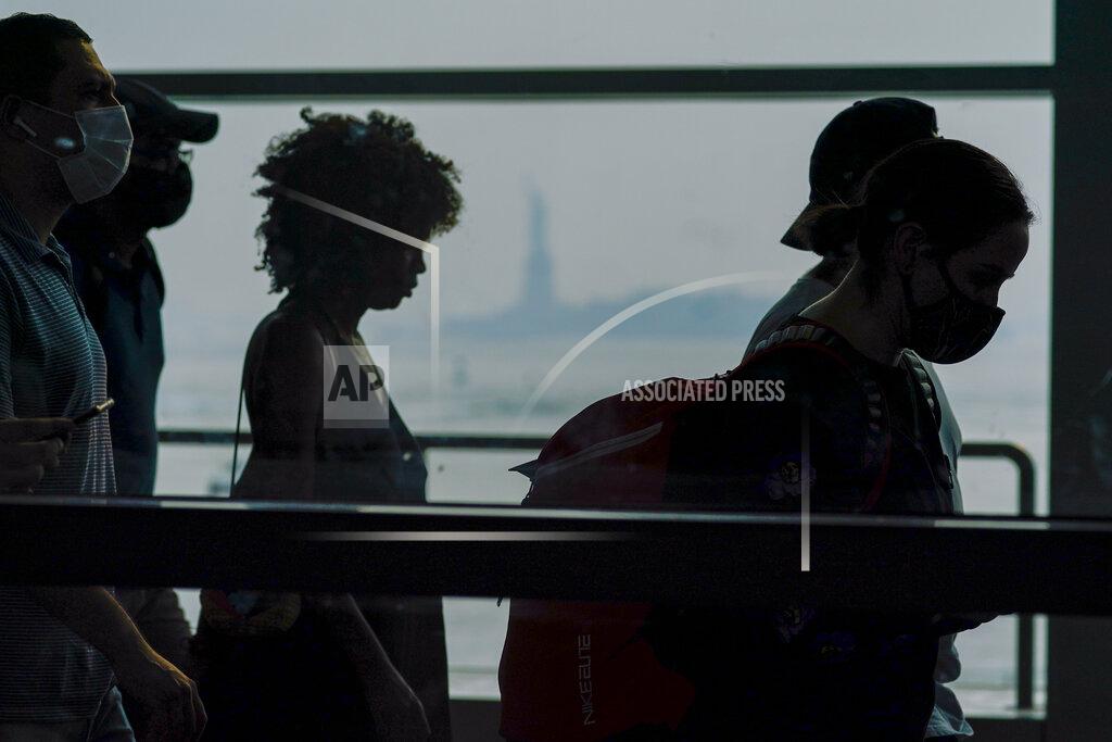 Mary Altaffer Staten Island ferry commuters walk past a view of the Statue of Liberty seen through haze, Tuesday, July 20, 2021, in New York. Smoke from wildfires across the U.S. West, including Oregon's Bootleg Fire, has wafted over large swaths of the eastern United States. The New York City sky was hazy with smoke from fires thousands of miles away. David Lawrence, a meteorologist with the National Weather Service, said the skies could be hazy for the next couple weeks. (AP Photo/Mary Altaffer)