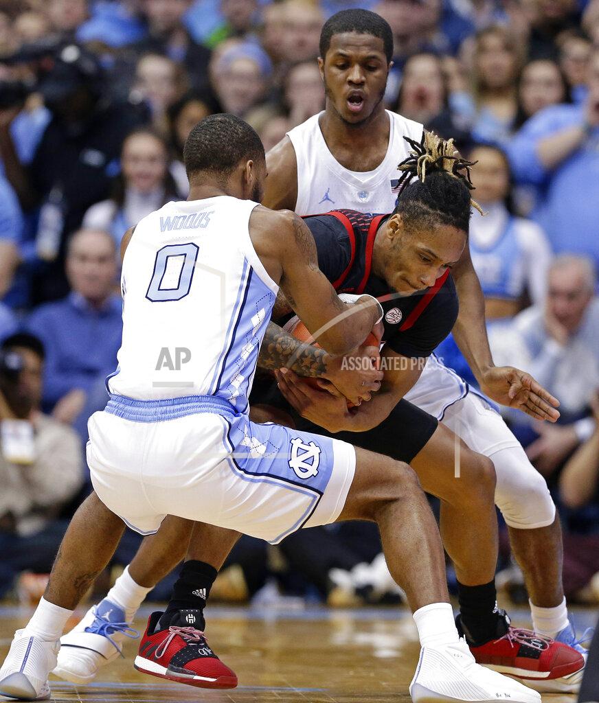 Gerry Broome North Carolina's Seventh Woods, left, and Kenny Williams, right, guard Louisville's Khwan Fore, center, during the first half of an NCAA college basketball game in Chapel Hill, N.C., Saturday, Jan. 12, 2019. (AP Photo/Gerry Broome)