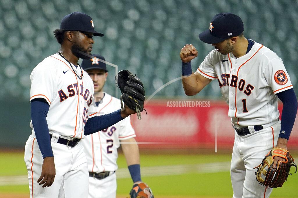 David J. Phillip Houston Astros starting pitcher Cristian Javier, left, gets a fist bump from second baseman Carlos Correa (1) as he waits for manager Dusty Baker to pull him during the sixth inning of a baseball game against the Los Angeles Dodgers Wednesday, July 29, 2020, in Houston. (AP Photo/David J. Phillip)