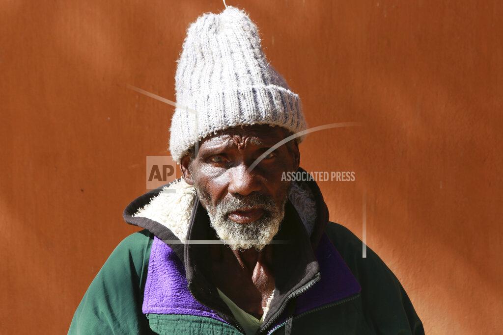 Tsvangirayi Mukwazhi Rodrick Bhatare an elderly man in his 90s sits outside Melfort Old People's home on the outskirts of Harare, Zimbabwe, Sunday, July 25, 2021. Just a week after arriving at the facility, Rodrick Bhatare, in his 90s, said he felt a bittersweet moment at the celebration for a 103-year old fellow resident. “I haven’t been this happy in a very long time,” he said. “I just wished I was doing it with my family.” Hard-hit by the pandemic, his family could no longer provide for him, he said. The economic ravages of COVID-19 are forcing some families in Zimbabwe to abandon the age-old tradition of taking care of their elderly. (AP Photo/Tsvangirayi Mukwazhi)